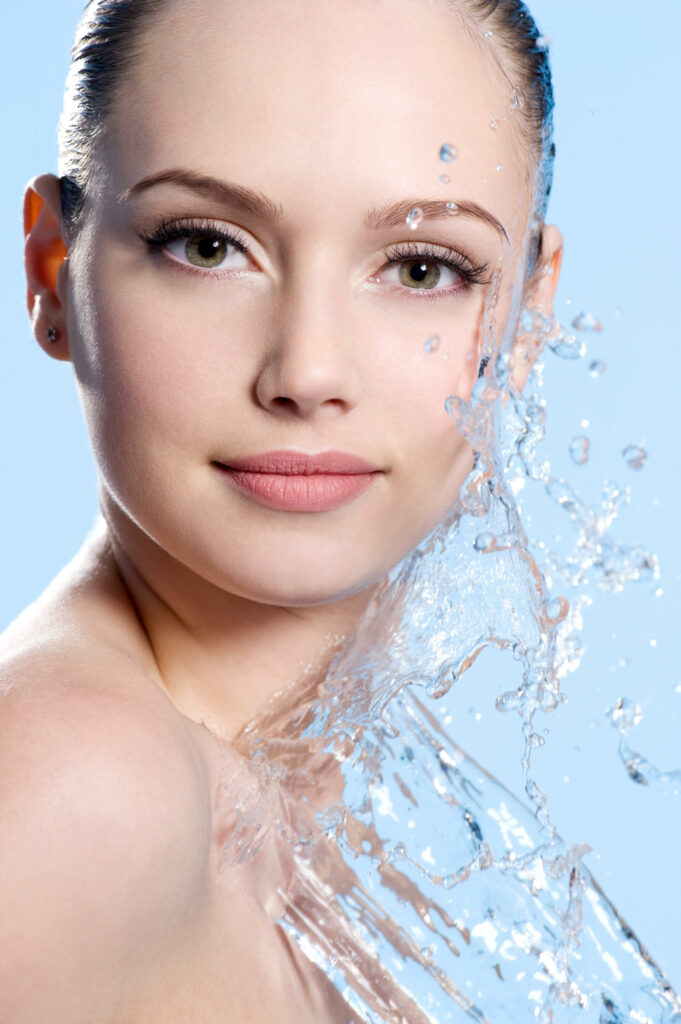 portrait young female face with splash water blue background